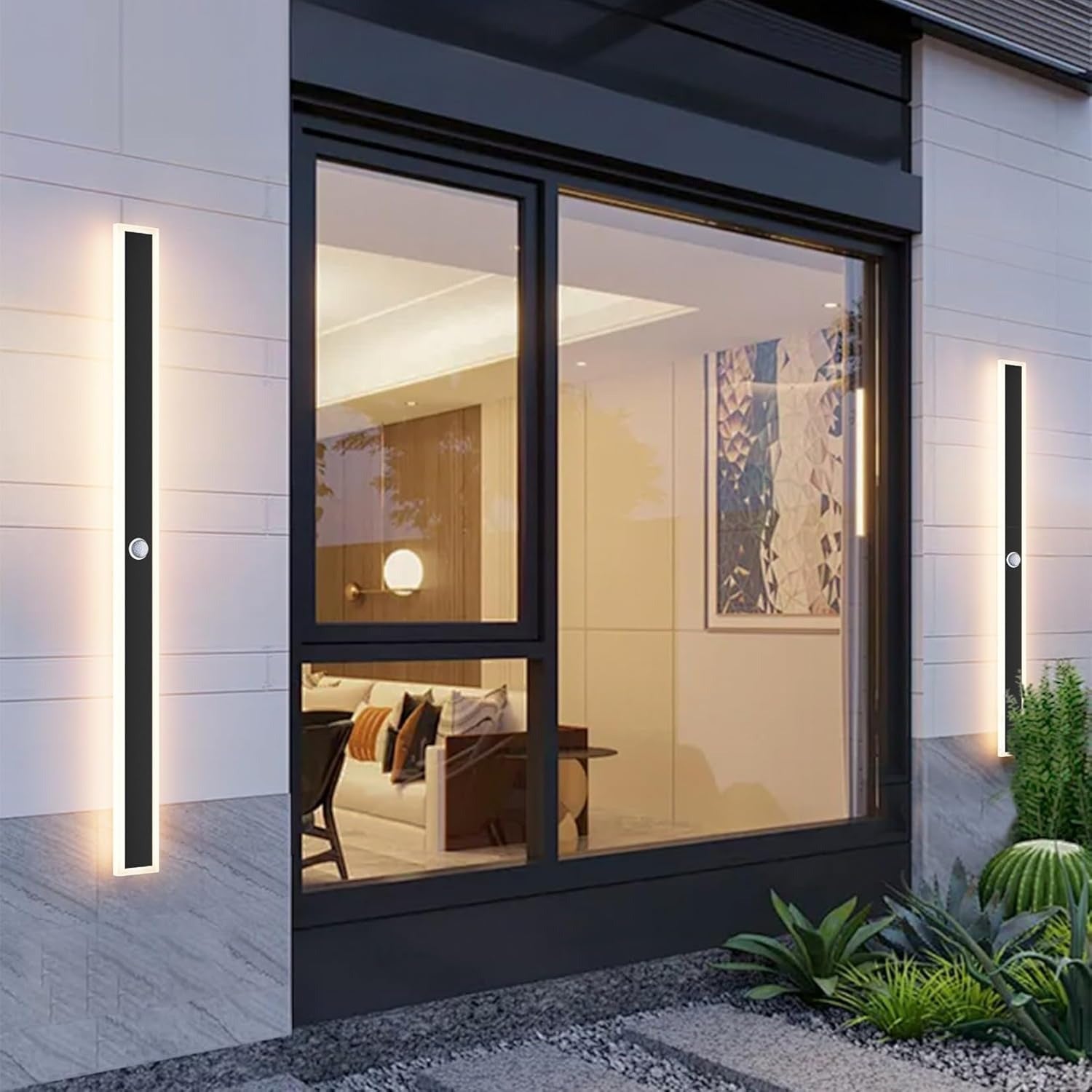 Modern glass door with black frame and wall lights on a building exterior.